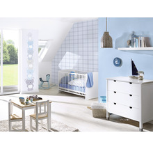 Ein Kinderzimmer mit einem Kinderbett, einer Kommode, einem Tisch und Stühlen.