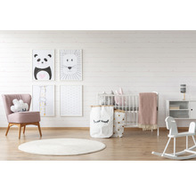 Babyzimmer mit Kinderbett, Sessel, Teppich, Spielzeug und Wandbildern