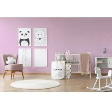 Kinderzimmer mit Babybett, Sessel, Spielzeug und Bildern an der Wand
