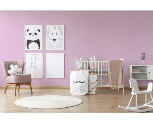 Kinderzimmer mit Babybett, Sessel, Spielzeug und Bildern an der Wand