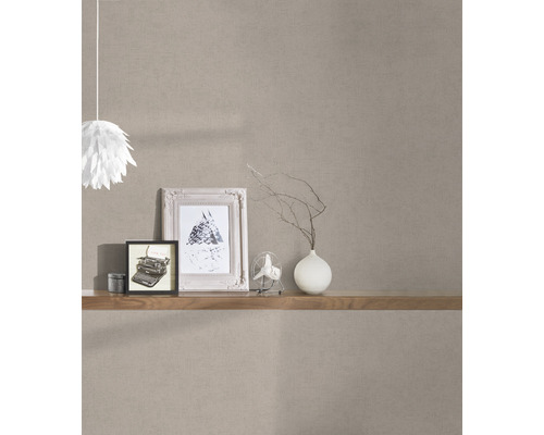 Dekoratives Zimmer mit brauner Vliestapete, Regal, Bildern und Lampe