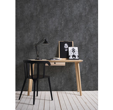 Arbeitszimmer mit Schreibtisch, Stuhl und Dekoration vor dunkler Wand