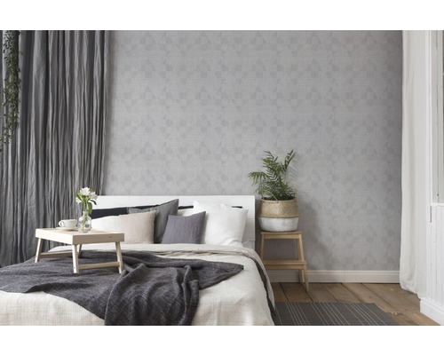 Helles Schlafzimmer mit Bett, Nachttisch und geometrischer Tapete