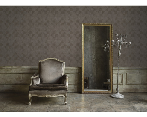 Raumansicht mit gemusterter Tapete, Sessel, Spiegel und Kerzenständer
