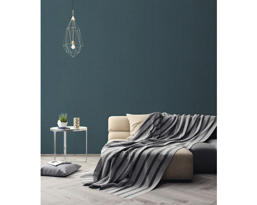 Salon avec canapé, couverture, table et suspension pour une atmosphère chaleureuse