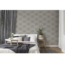 Schlafzimmer mit Bett vor einer Wand mit Tapete mit geometrischem Muster