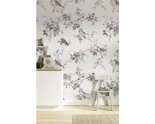 Pièce avec papier peint à motifs d''oiseaux et de fleurs, une armoire blanche et une chaise.