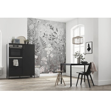 Heller Raum mit Küchentisch, Stuhl, Schrank mit Backofen und Wandtapete mit Blumenmuster.