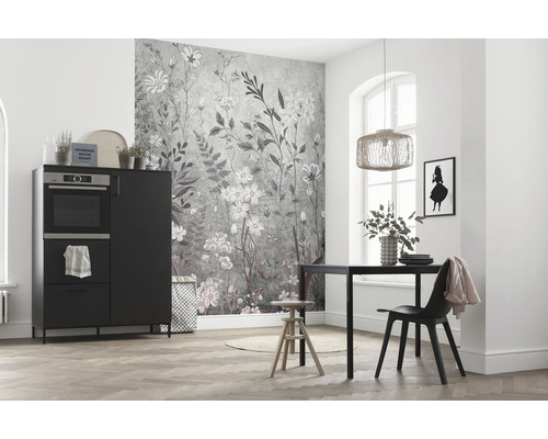 Heller Raum mit Küchentisch, Stuhl, Schrank mit Backofen und Wandtapete mit Blumenmuster.