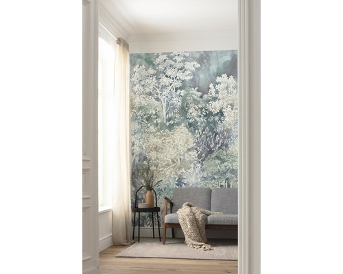 Salon avec papier peint forêt, canapé, table d''appoint et tapis.