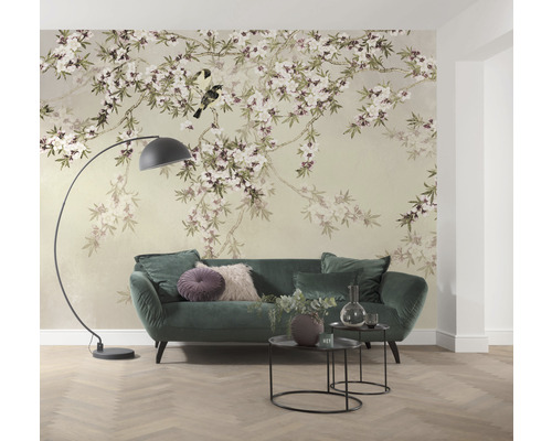 Salon avec papier peint floral, canapé, lampadaire et tables d''appoint