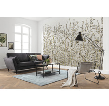Wohnzimmer mit Sofa, Teppich, Stehlampe, Stuhl und gemusterter Tapete mit Pflanzenmotiven