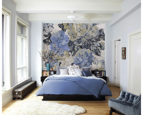 Chambre avec papier peint floral, lit et tables de chevet.