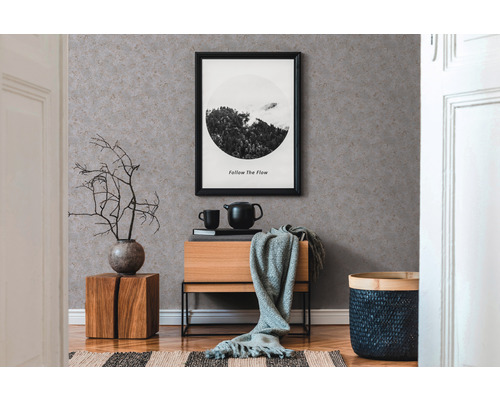 Intérieur avec papier peint à motifs, commode et éléments décoratifs pour une ambiance chaleureuse.