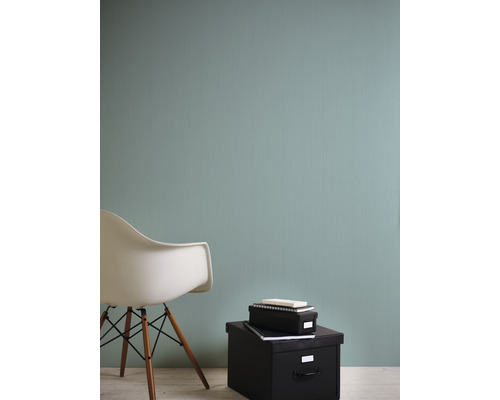 Nahaufnahme einer Wand mit einer Textiltapete, einem Stuhl und Aufbewahrungsboxen