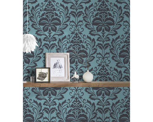 Wandgestaltung mit gemusterten Tapeten und Dekorationsartikeln auf einem Regalbrett