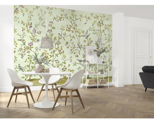 Une salle à manger avec un papier peint à motifs d''oiseaux et de fleurs, une table à manger et des chaises.