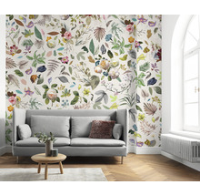 Wohnzimmer mit Sofa und floraler Tapete mit Blättern und Blüten.