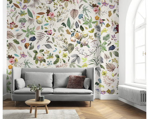 Salon avec canapé et papier peint floral avec feuilles et fleurs.