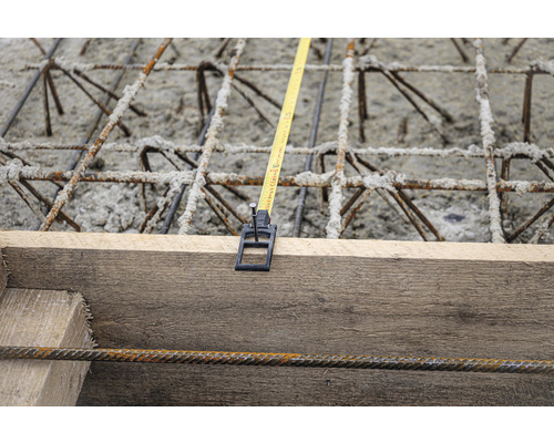 Betonbewehrung mit Holzschalung und Messband