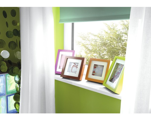 Dekoratives Wohnzimmer mit Fenster, Vorhängen und bunten Bilderrahmen