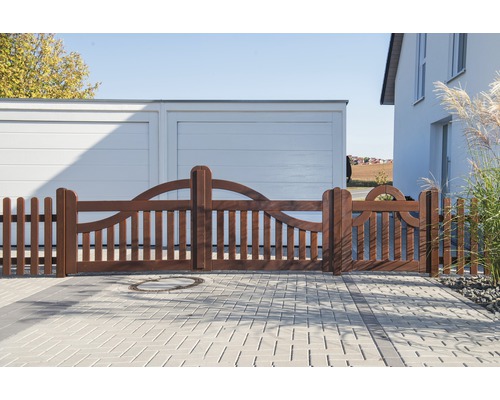 Braunes Holztor mit Lattenzaun vor einem Haus und einer Garage