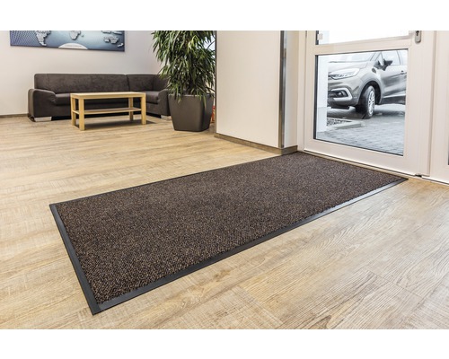 Schmutzfangmatte vor einer Tür in einem hellen Raum.