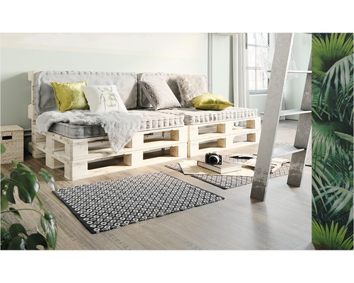 Wohnzimmer mit Palettensofa, Kissen und Teppich auf Holzboden