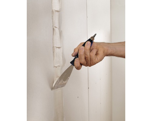 Hand verspachtelt Fugen an einer Gipskartonwand mit einem Spachtel