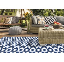 Terrasse avec tapis d''extérieur à motif triangulaire, salon de jardin en rotin et balançoire en bois
