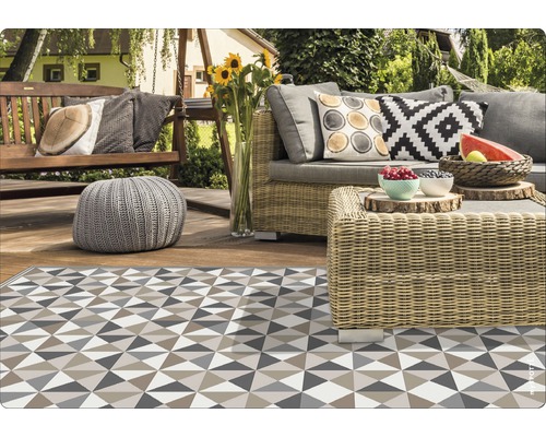 Terrasse mit Rattansitzgruppe, Sitzschaukel und gemustertem Teppich