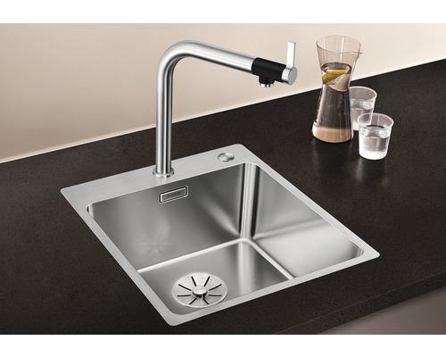 Edelstahlspüle mit Armatur auf dunkler Arbeitsplatte