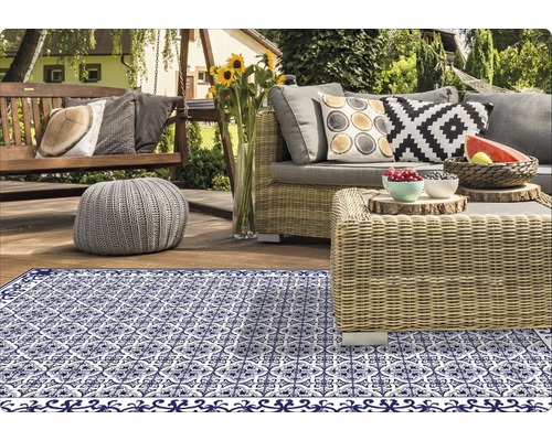 Dekorativer Teppich auf einer Terrasse mit Gartenmöbeln.