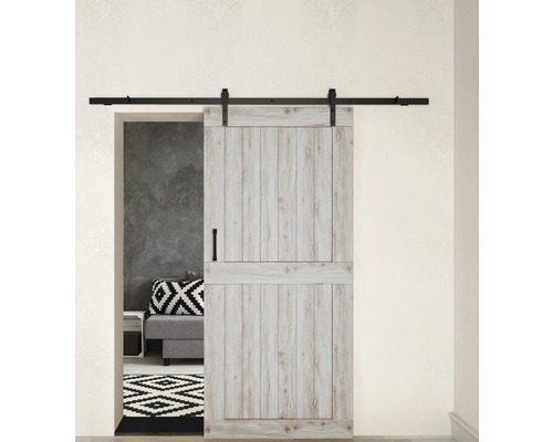 Porte coulissante en bois de style grange avec quincaillerie devant une scène de salon