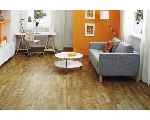 Salon avec parquet clair, canapé, table et bureau