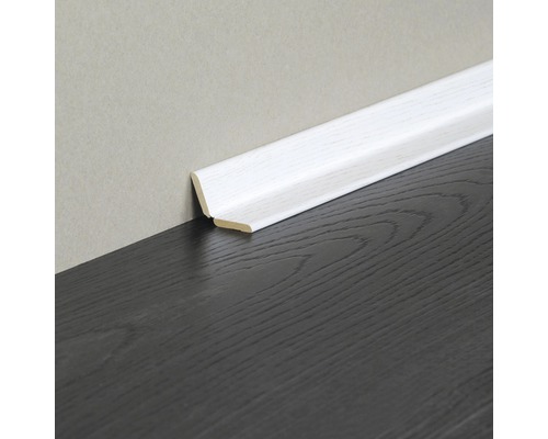 Plinthe blanche en bois sur plancher en bois foncé et mur clair