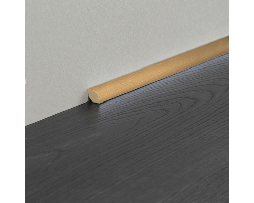 Quart de rond en bois comme finition murale sur un sol en bois foncé