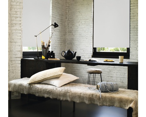 Pièce lumineuse avec store enrouleur, bureau et siège.