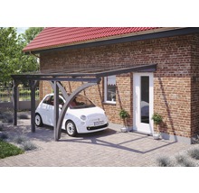 Abri de voiture en bois avec voiture devant une maison en briques