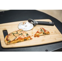 Deux parts de pizza et roulette à pizza sur planche à découper en bois