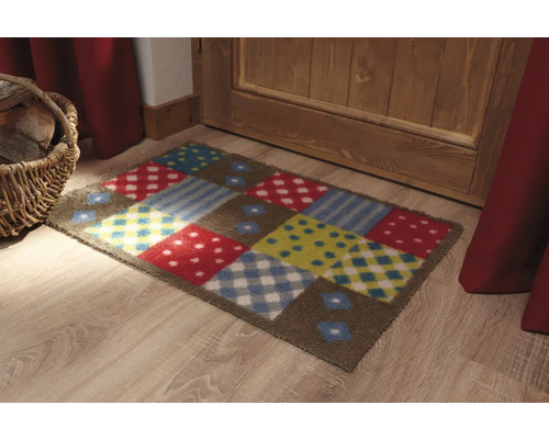 Bunte Fußmatte mit verschiedenen Mustern vor einer Tür.