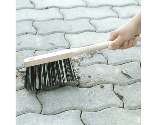 Fugenbürste mit Holzstiel reinigt Pflastersteine von Unkraut