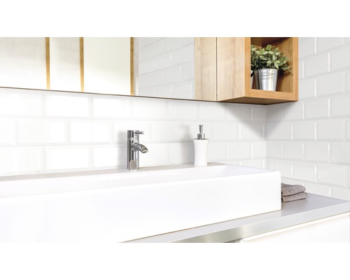 Modernes Badezimmer mit Waschbecken, Armatur, Seifenspender und weißen Fliesen