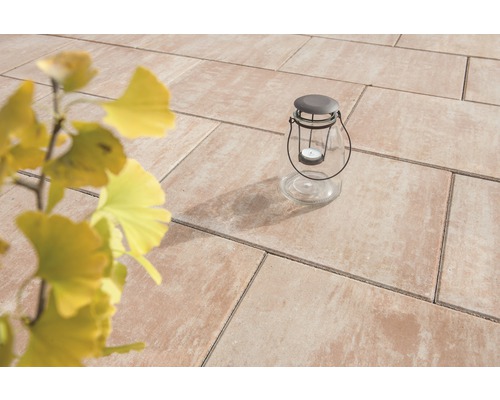 Scène de jardin avec dalles de terrasse et lanterne en verre avec bougie