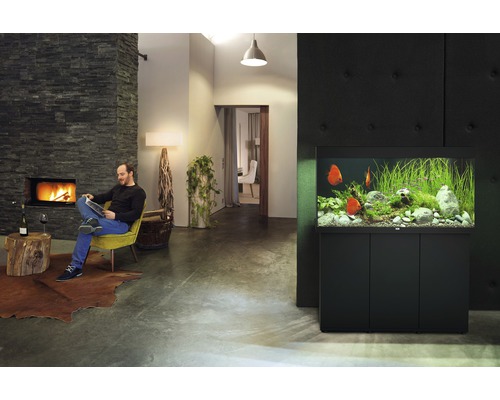 Wohnzimmer mit Aquarium, Kamin und lesendem Mann