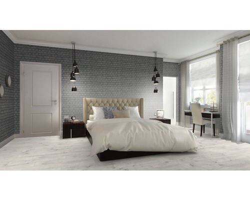 Chambre lumineuse avec lit, tables de chevet, bureau et mur de briques