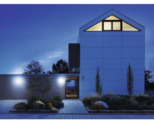 Modernes Wohnhaus mit Fassadenbeleuchtung und gepflastertem Weg