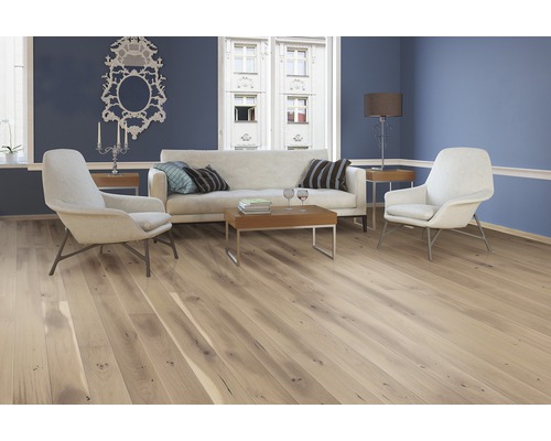 Heller Wohnraum mit Holzboden, Sofa und Sesseln für ein gemütliches Ambiente.