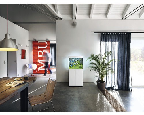 Salon avec aquarium sur meuble bas, table et chaises.