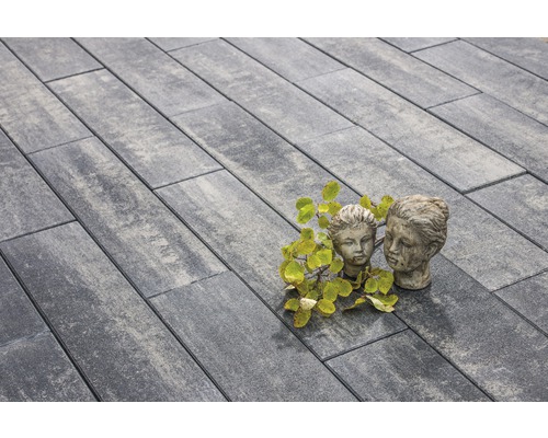 Verlegung von grauen Pflastersteinen mit zwei Statuen